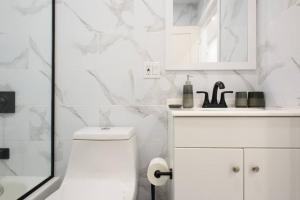 bagno bianco con servizi igienici e lavandino di 240-14 NEW Studio Prime Location W&D in unit a New York