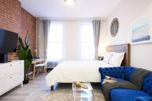- une chambre avec un lit et un canapé bleu dans l'établissement 240-5 NEW Prime Location STUDIO W&D in unit, à New York