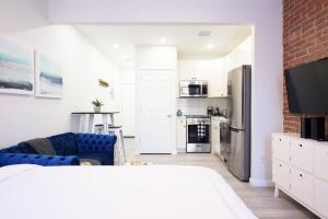 un soggiorno con divano blu e una cucina di 240-5 NEW Prime Location STUDIO W&D in unit a New York