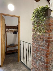um quarto com uma parede de tijolos e uma porta com uma planta em Locanda Tarello1880 em Roppolo
