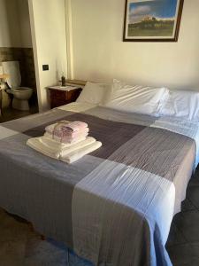 a bed with a pile of towels on top of it at Locanda Tarello1880 in Roppolo
