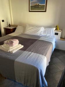 Locanda Tarello1880 في Roppolo: غرفة نوم بسرير كبير عليها مناشف