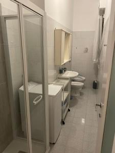 La salle de bains est pourvue de 2 toilettes, d'un lavabo et d'une douche. dans l'établissement Ale E-Commerce Holiday Home, à Buccinasco