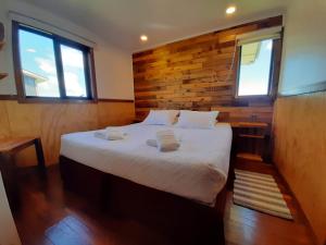 a bedroom with a bed with two towels on it at Cabañas Natales Rotundo in Puerto Natales