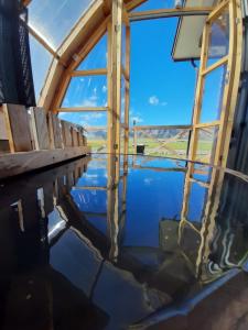 a reflection of a window in a body of water at Cabañas Natales Rotundo in Puerto Natales