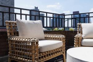 a wicker chair sitting on top of a balcony at 809-6B 2BR Duplex Breathtaking Views Beauty in New York