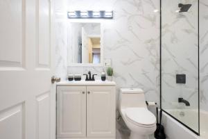 a white bathroom with a toilet and a shower at 240-9 Luxury Prime Location STUDIO W&D in New York
