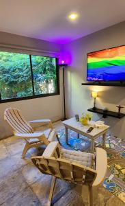 sala de estar con sillas, mesa y TV en Monoambiente en casa familiar en Mar de Ajó