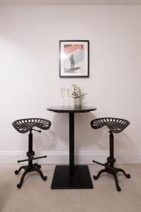 a table with two chairs and a table with glasses on it at Super King , Stunning apartment in Harrogate. in Harrogate