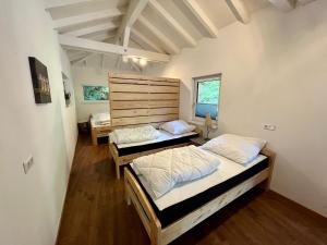 two beds in a room with two windows at Zauberhaftes Waldhaus in Blaubeuren