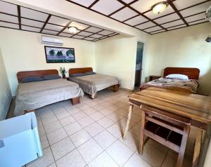 a room with two beds and a table in it at Brisa Del Mar in Playa Hermosa