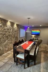 comedor con mesa y pared de piedra en Monoambiente en casa familiar en Mar de Ajó