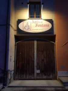 uma porta para um edifício com um sinal por cima em B&B Antica Fontana em Bernezzo
