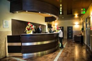 grupa ludzi stojąca przy barze w holu w obiekcie Hotel Monttis w mieście Sucha Beskidzka