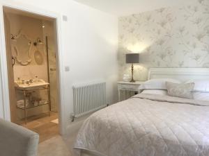 a bedroom with a bed and a bathroom with a sink at Abbey Green Farm in Wem
