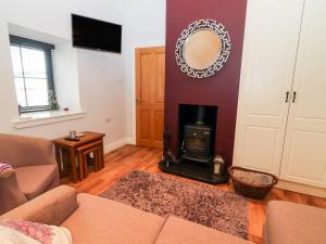 a living room with a fireplace and a mirror at Laharn Cottage in Killorglin