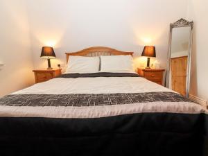 a bedroom with a large bed with two lamps at Laharn Cottage in Killorglin