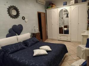 - une chambre dotée d'un lit bleu avec des oreillers et un miroir dans l'établissement Rosaspina, à Grosseto