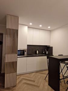 a kitchen with white cabinets and a table at Parko nauji apartamentai in Panevėžys +10 photos