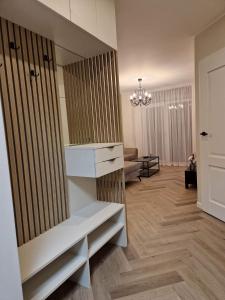 - un salon avec un canapé et un lustre dans l'établissement Parko nauji apartamentai, à Panevėžys