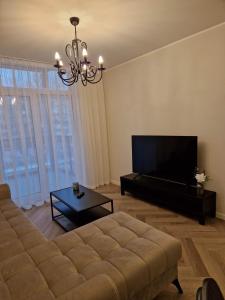 a living room with a couch and a flat screen tv at Parko nauji apartamentai in Panevėžys