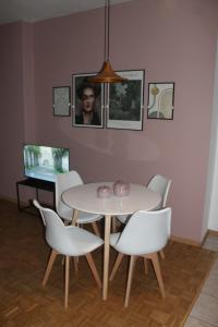 une salle à manger avec une table blanche et des chaises blanches dans l'établissement Appartamento Perini, à Trente