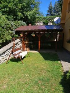einen Stuhl in einem Garten mit Pavillon in der Unterkunft Chata Kubko in Bobrovník