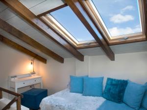 a bedroom with a bed with blue pillows and a window at Parnassos Chalets in Arachova