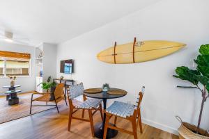 a room with a table and a surfboard on the wall at Peninsula Paradise in San Diego