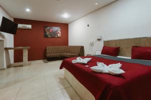a bedroom with a red bed with two white towels at Auto Hotel Las Maravillas in Santa Cruz Xoxocotlán