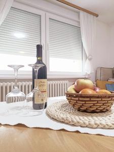 uma garrafa de vinho e uma cesta de frutas sobre uma mesa em Studio Apartment Dobrinja em Sarajevo