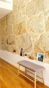 a bench in a room with a stone wall at Famous Dreaming Studio in Porto