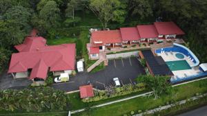 a house with a red roof and a swimming pool at Hotel Cielo Azul Resort in Tilarán