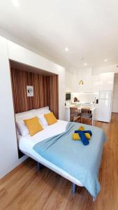 a bedroom with a large bed and a kitchen at Famous Dreaming Studio in Porto