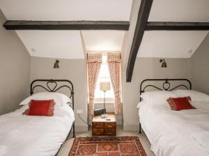 1 dormitorio con 2 camas y ventana en Bryn Tegid, en Beaumaris
