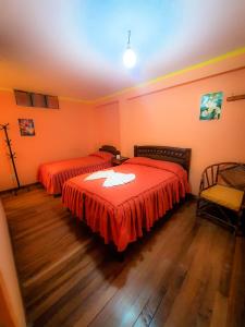 una camera con due letti con lenzuola rosse di HOSTAL Luz YHOBIMAR a Copacabana