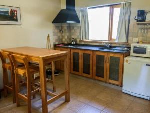 cocina con mesa de madera y fregadero en Roca 3 en San Martín de los Andes