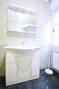 a bathroom with a white sink and a mirror at Apartamento da Pedra e da Auga in Meis