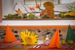 einen Tisch mit einer Kerze und einer Sonnenblume darauf in der Unterkunft Löwenhof in Krumbach
