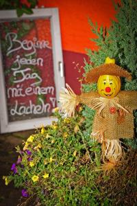 un espantapájaros con un sombrero de paja en un arbusto en Löwenhof, en Krumbach