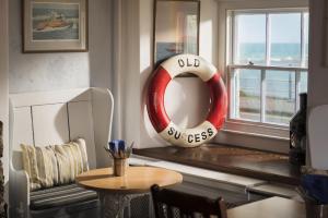 a living room with a red and white lifesaver in a window at The Old Success Inn in Sennen Cove