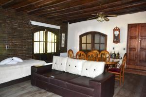 a bedroom with a bed and a couch and a table at NUESTRA CASA EN CHACRAS DE CORIA (Bª PRIVADO) in Chacras de Coria