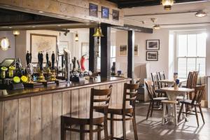 a bar in a restaurant with chairs and tables at The Old Success Inn in Sennen Cove