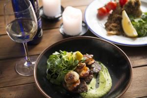 a table with two plates of food and a glass of wine at The Old Success Inn in Sennen Cove