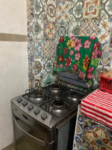 a stove in a kitchen with a tile wall at Kitnet Arembepe - Aconchego da Lulu in Arembepe