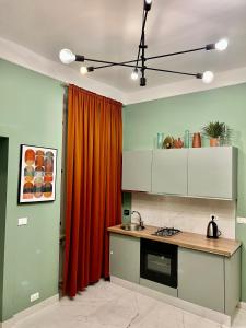 - une cuisine avec un rideau orange et un évier dans l'établissement Casa Lorenzo, à Rome