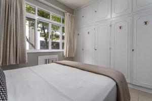 1 dormitorio blanco con 1 cama y 2 ventanas en Charmoso em Copacabana - 1 Quarto - JN301 Z2, en Río de Janeiro