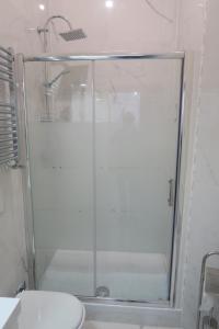 La salle de bains est pourvue d'une douche avec une porte en verre. dans l'établissement Casa Lorenzo, à Rome