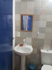 y baño con lavabo, aseo y espejo. en Apartamento perto de praia Dos Anjos 2, en Arraial do Cabo