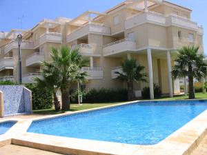 a villa with a swimming pool in front of a building at El Faro - Serviden in Denia
